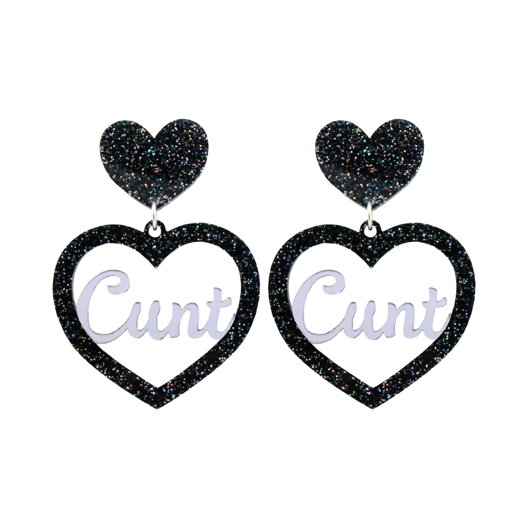  An image of Haus of Dizzy's Small ‘Cunt' heart shaped dangle earrings, with mirror "Cunt" text on a Black Glitter acrylic stud heart.