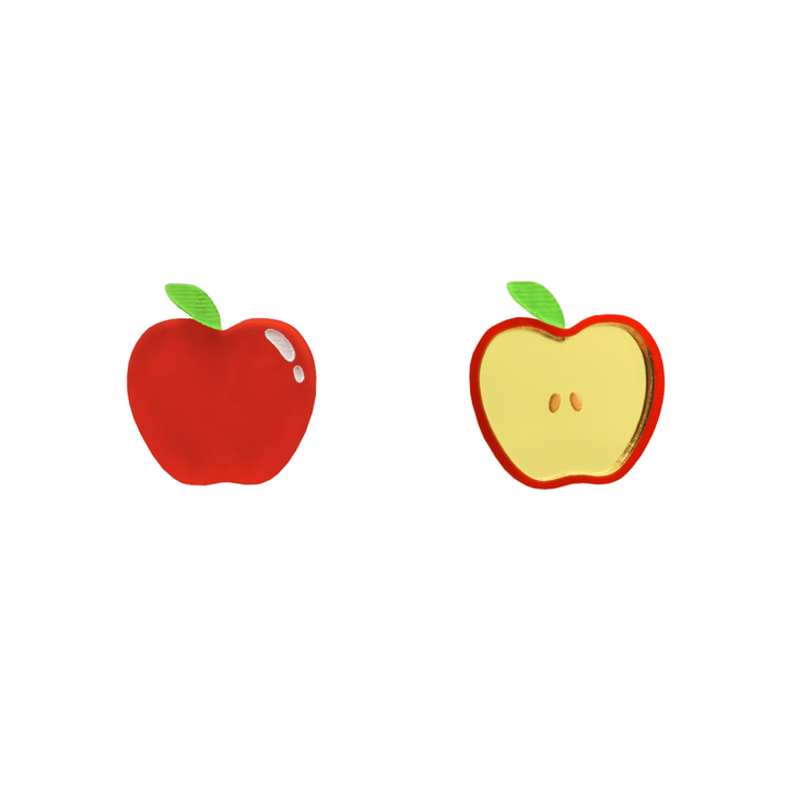 An image of Haus of Dizzy's an apple a day studs, with one full apple and one cut apple, with red and gold mirror acrylic and green paintfill.