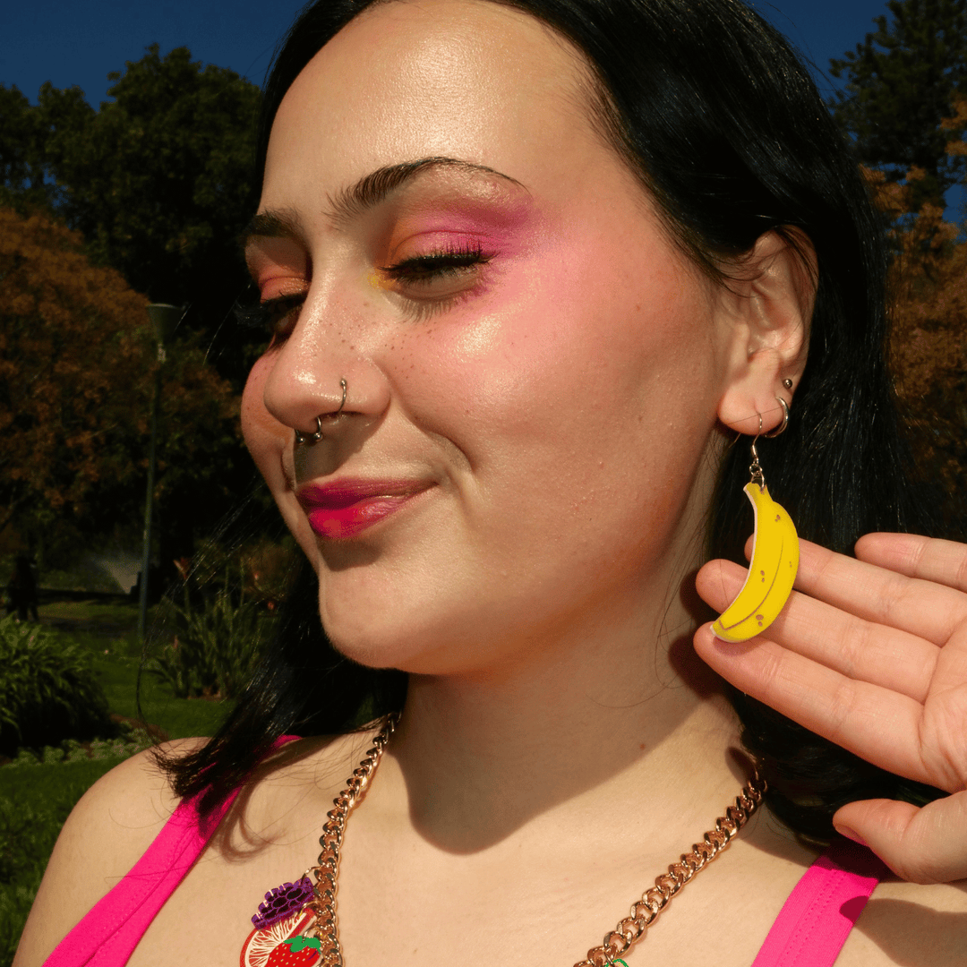 side profile shot of model wearing haus of dizzys full banana earrings made from yellow acrylic and hand painted brown and black detailing