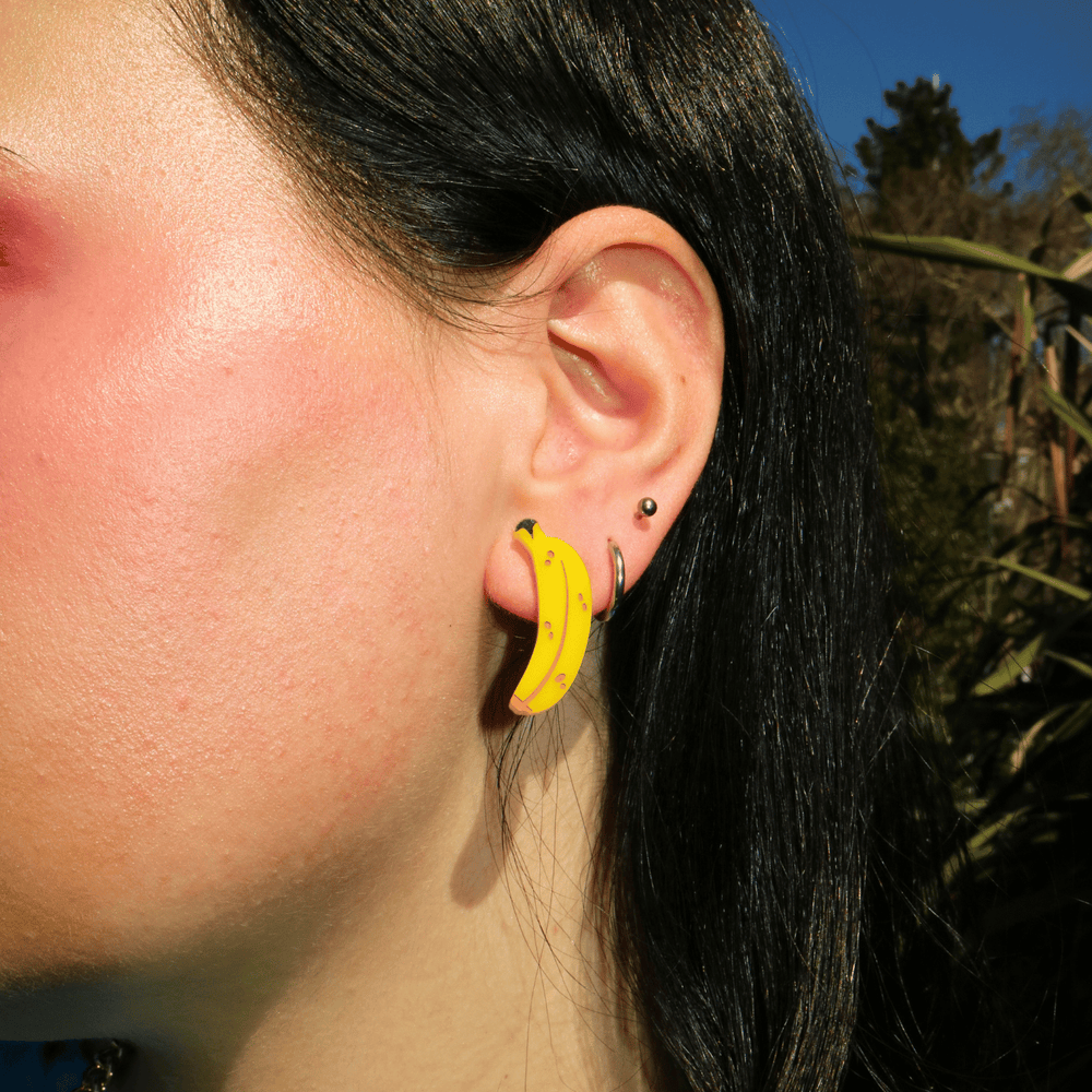 close up shot of model wearing haus of dizzy's banana shaped studs
