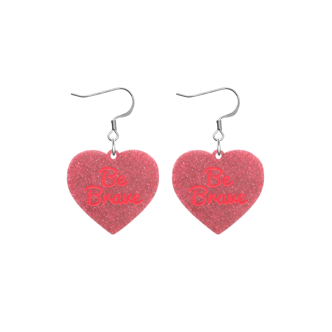 haus of dizzy baby pink glitter heart-shaped acrylic earrings with bright red 'Be Brave' text and silver hooks no heart tops size small