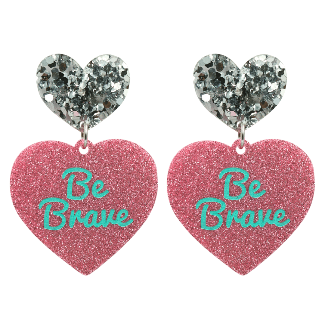 haus of dizzy baby pink glitter heart-shaped acrylic earrings with turquoise 'Be Brave' text and chunky silver glitter heart tops size large