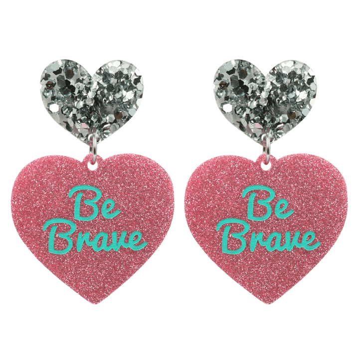 haus of dizzy baby pink glitter heart-shaped acrylic earrings with turquoise 'Be Brave' text and chunky silver glitter heart tops size large