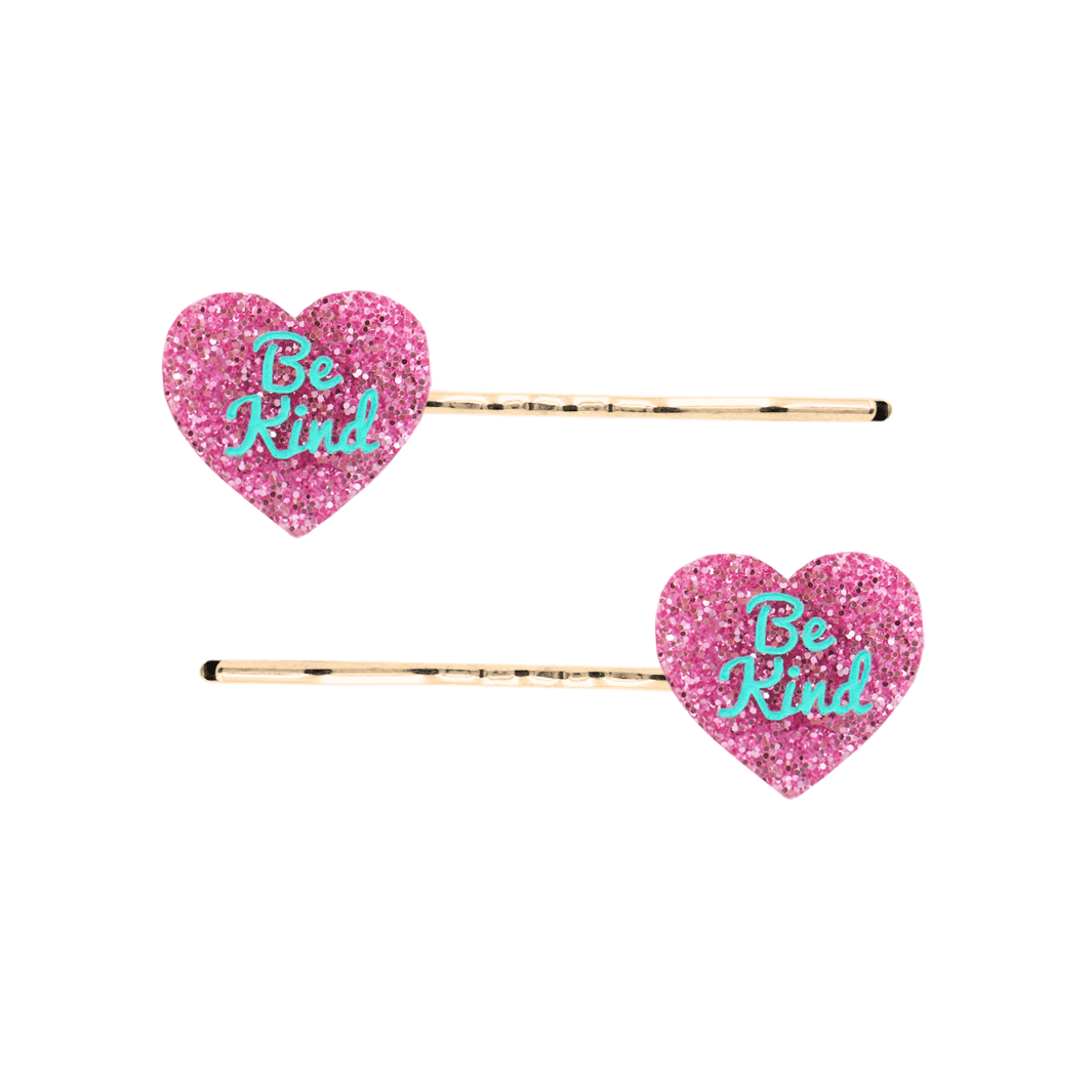 haus of dizzy two pink glitter heart-shaped acrylic pieces with aqua 'Be Kind' text on gold bobby hair pins