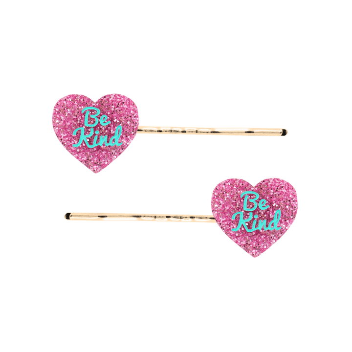 haus of dizzy two pink glitter heart-shaped acrylic pieces with aqua 'Be Kind' text on gold bobby hair pins