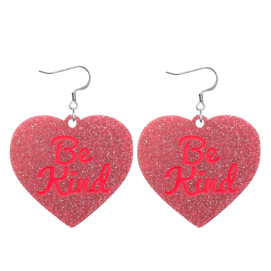 haus of dizzy baby pink glitter heart-shaped acrylic earrings with bright red 'Be Kind' text and silver hooks no heart tops size large