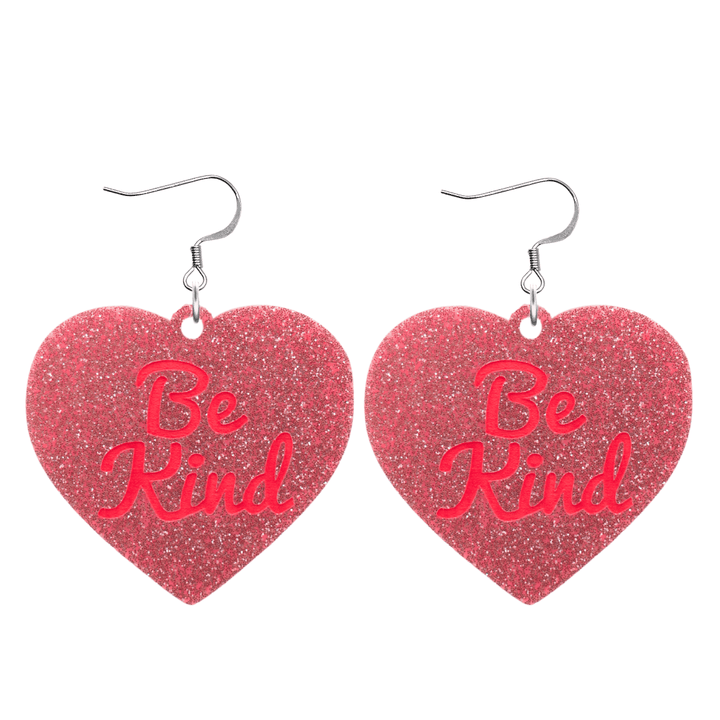 haus of dizzy baby pink glitter heart-shaped acrylic earrings with bright red 'Be Kind' text and silver hooks no heart tops size large