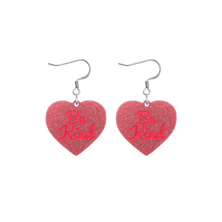 haus of dizzy baby pink glitter heart-shaped acrylic earrings with bright red 'Be Kind' text and silver hooks no heart tops size small