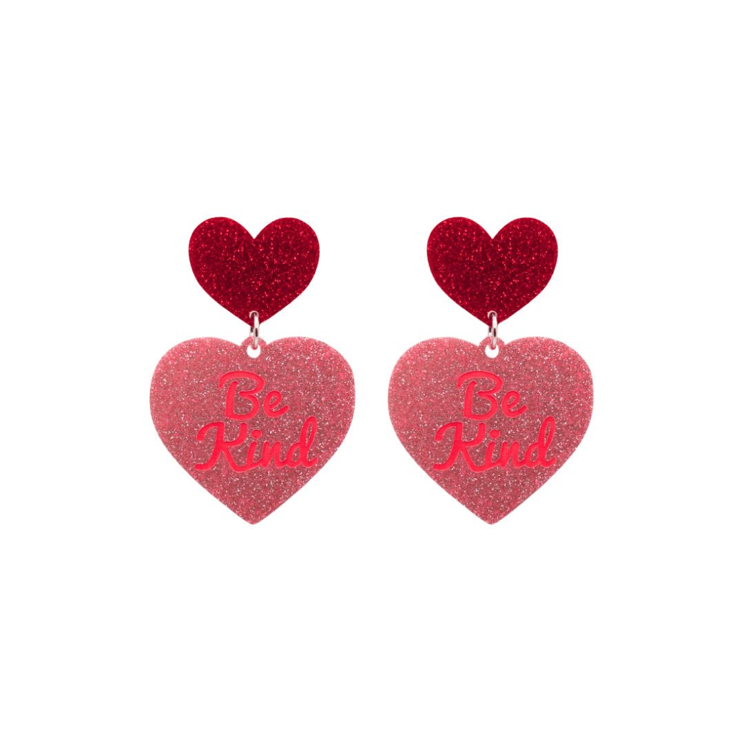haus of dizzy baby pink glitter heart-shaped acrylic earrings with bright red 'Be Kind' text and red glitter heart tops size small
