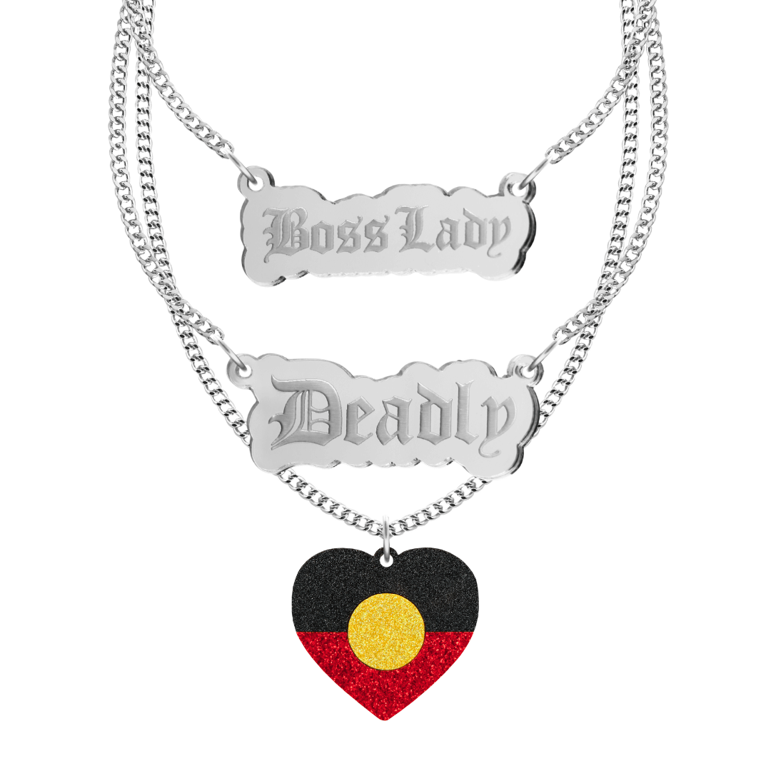 haus of dizzy three tier stacked necklace set with two silver pendants, one says boss lady the other says deadly, the third necklace has an aboriginal flag glitter heart. all on silver chain