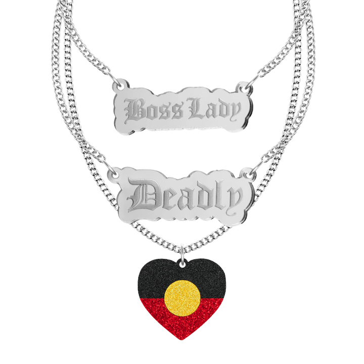 haus of dizzy three tier stacked necklace set with two silver pendants, one says boss lady the other says deadly, the third necklace has an aboriginal flag glitter heart. all on silver chain