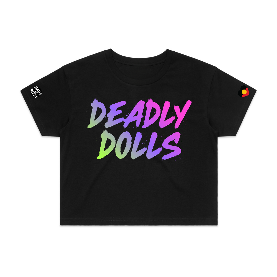image of haus of dizzy black short-sleeve crop top t-shirt featuring the words 'DEADLY DOLLS' printed in a bold rainbow gradient brush-stroke font across the chest. haus of dizzy logo decal on right sleeve and aboriginal heart flag decal on left sleeve.