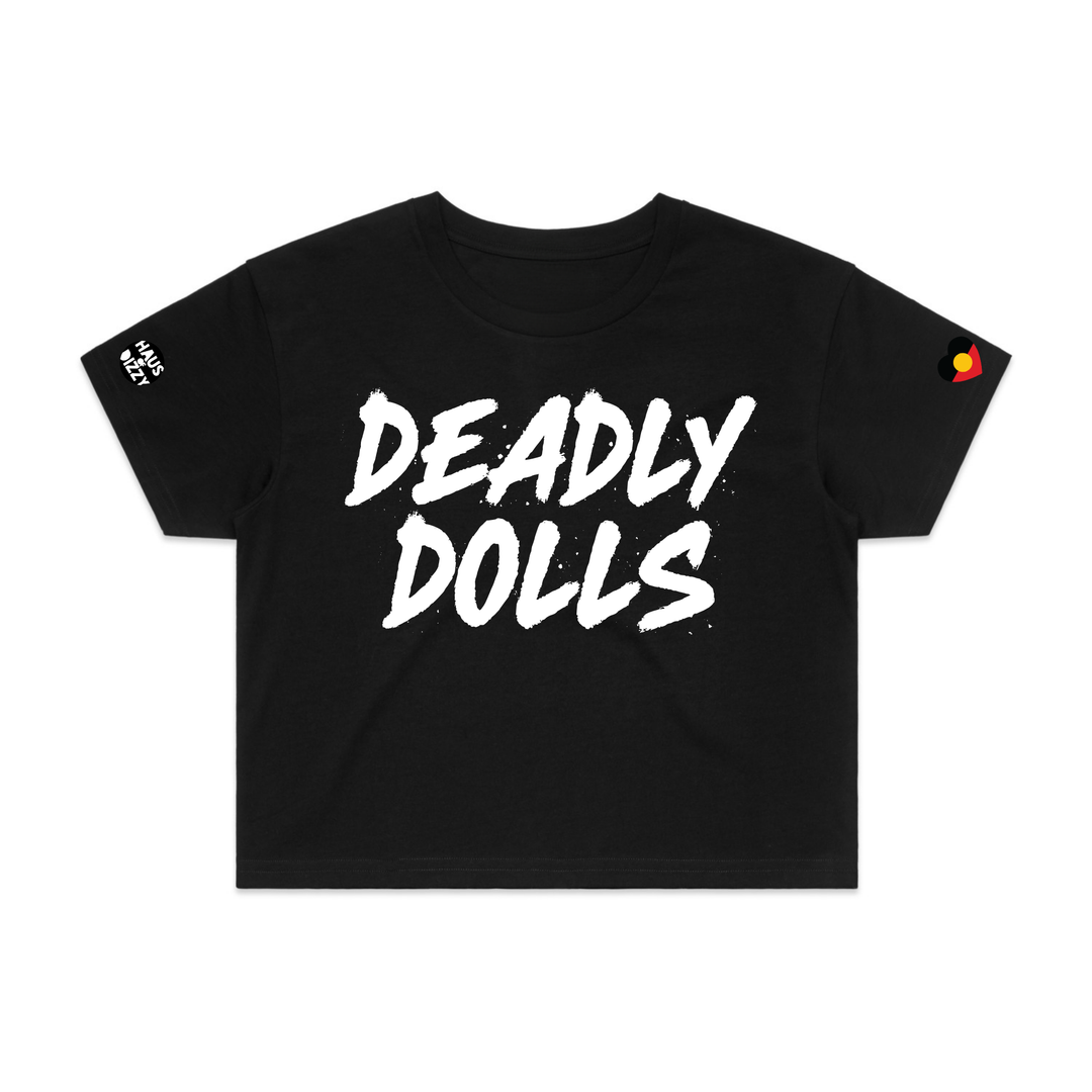 image of haus of dizzy black short-sleeve crop top t-shirt featuring the words 'DEADLY DOLLS' printed in a bold white brush-stroke font across the chest. haus of dizzy logo decal on right sleeve and aboriginal heart flag decal on left sleeve.