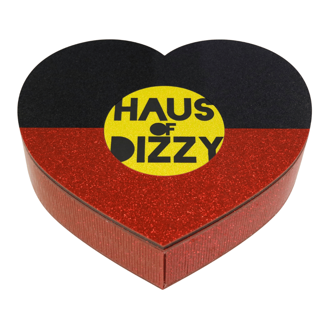 hand made heart-shaped acrylic jewellery box in Aboriginal flag colours. using black, yellow, and red glitter acrylic with hand painted haus of dizzy logo in yellow sun centre front view