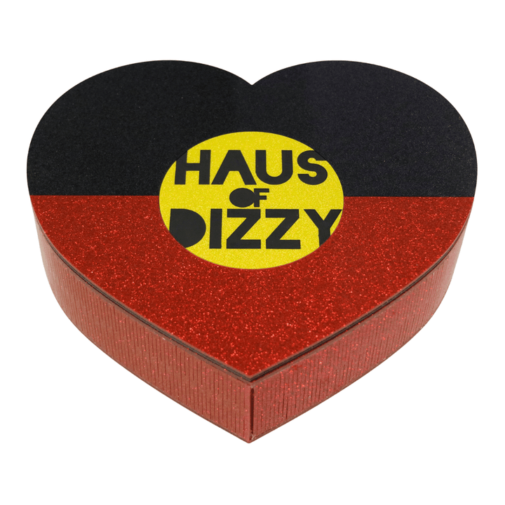 hand made heart-shaped acrylic jewellery box in Aboriginal flag colours. using black, yellow, and red glitter acrylic with hand painted haus of dizzy logo in yellow sun centre front view