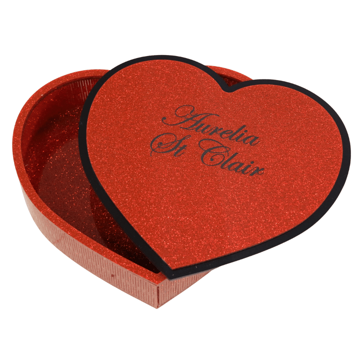 hand made heart-shaped acrylic jewellery box in Aboriginal flag colours. box lid is upside down revealing custom engraving which is an additional $10, black cursive font reads aurelia st clair