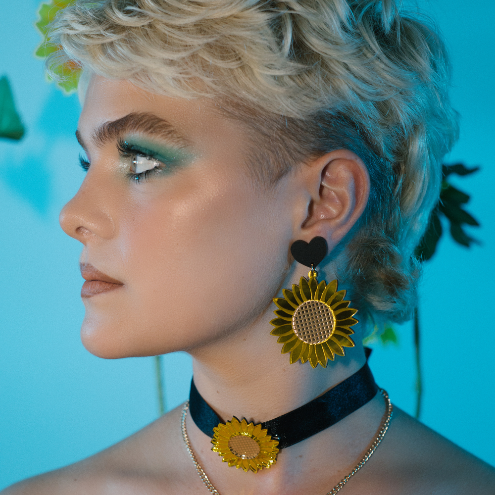 image of model wearing haus of dizzy mirror sunflower earrings facing away from camera 