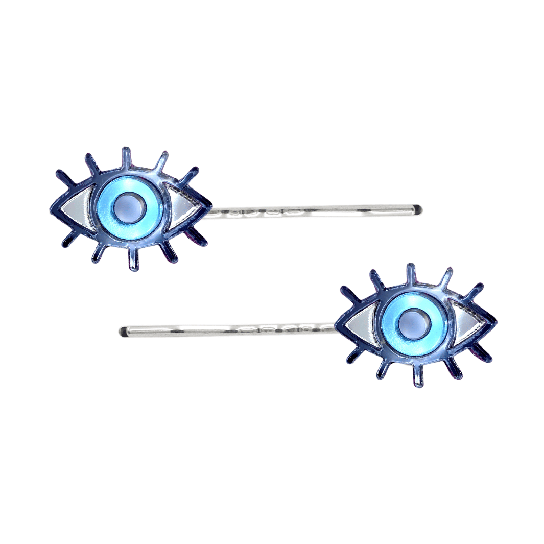 haus of dizzy eye see you hair pins set of two. Eye-shaped hair pins with blue mirror centers and silver hairpins on a white background
