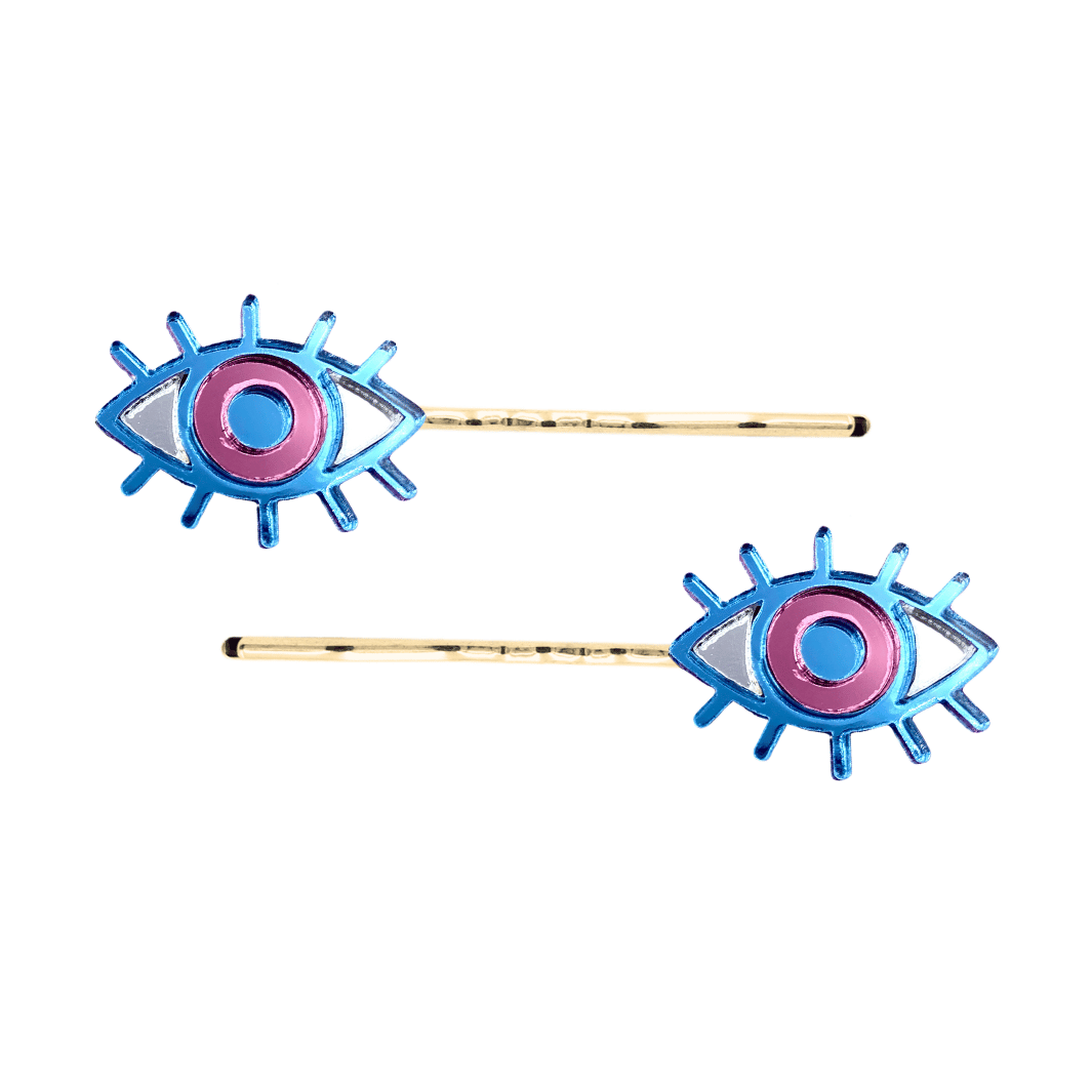 haus of dizzy eye see you hair pins set of two. Eye-shaped hair pins with pink mirror centers and gold hairpins on a white background