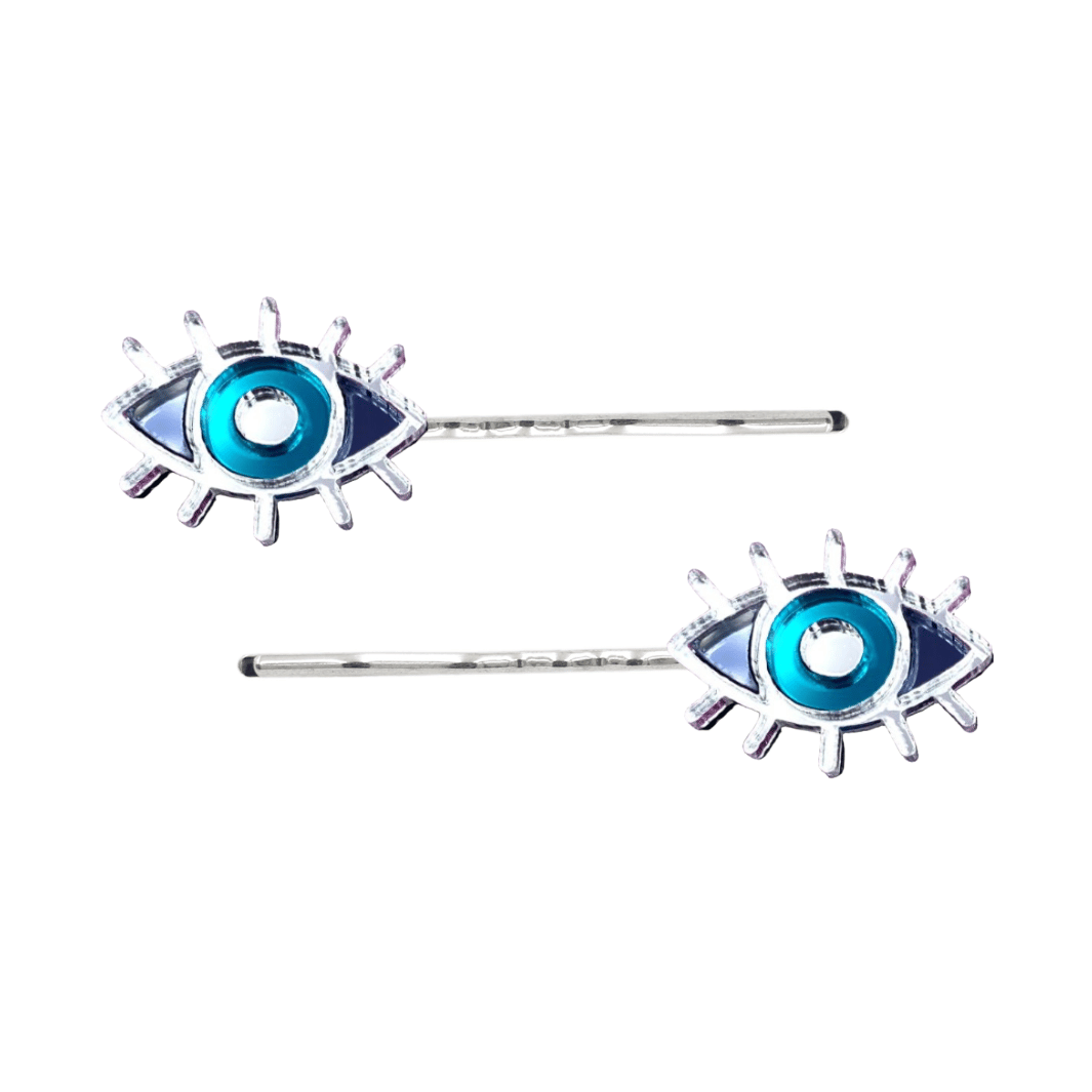 haus of dizzy eye see you hair pins set of two. Eye-shaped hair pins with teal mirror centers and silver hairpins on a white background