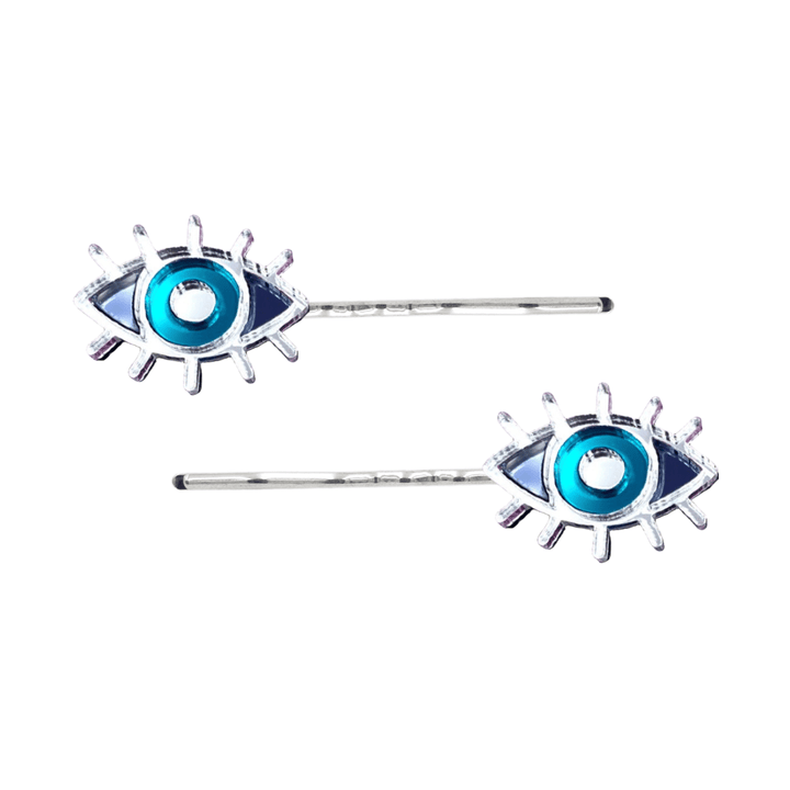 haus of dizzy eye see you hair pins set of two. Eye-shaped hair pins with teal mirror centers and silver hairpins on a white background