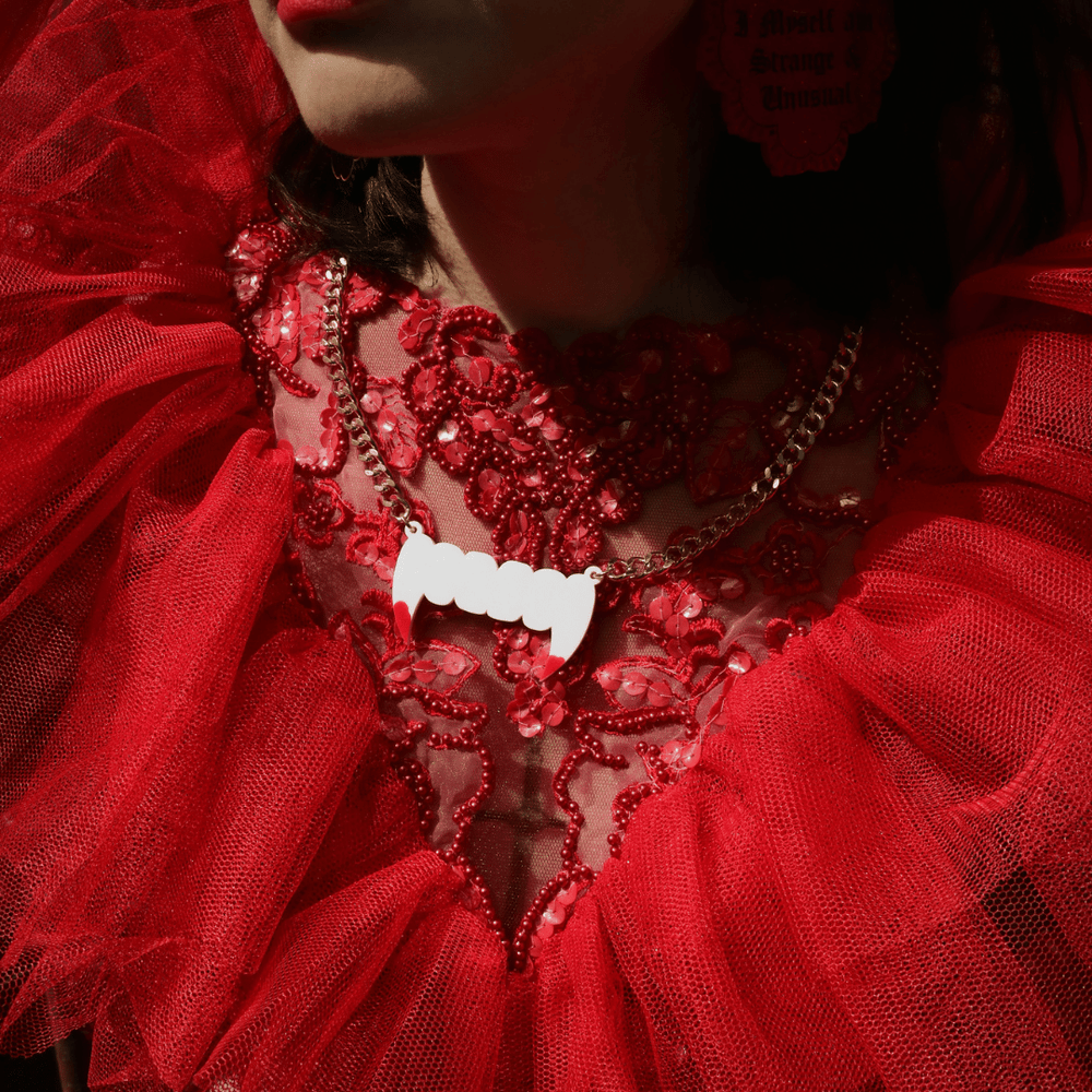 close up of haus of dizzys fang plate necklace halloween edition worn by model