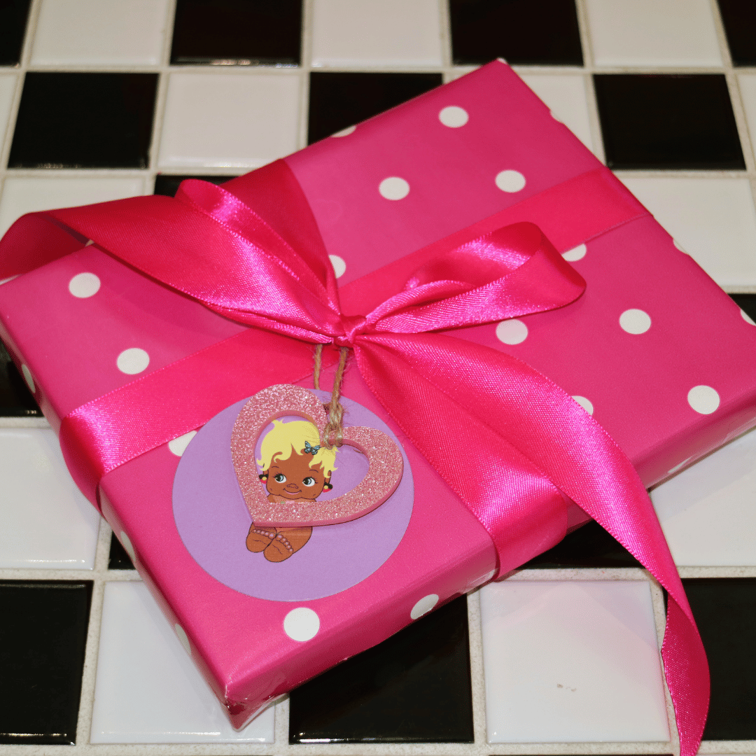 haus of dizzy seasonal gift wrapping. image features pink polka dot gift wrapping with a hot pink statement ribbon, collectable haus of dizzy acrylic glitter heart charm, and haus of dizzy character tag 