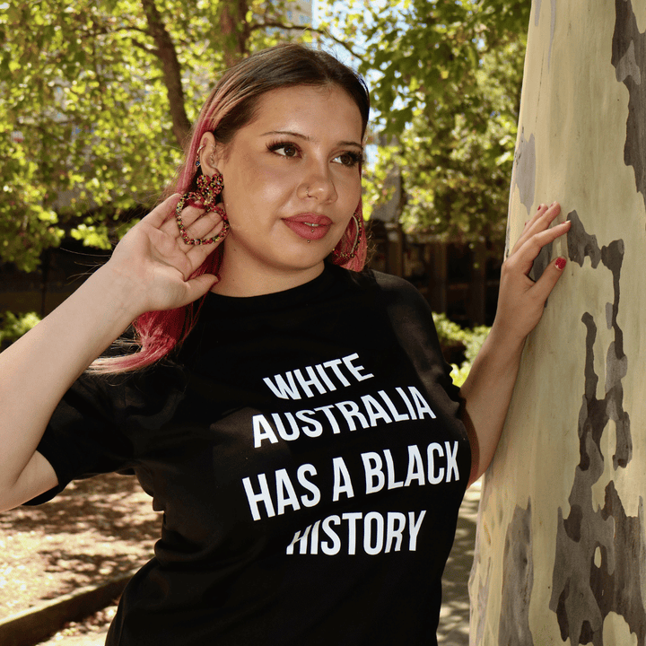 image of model wearing haus of dizzy giiny heart hoop earrings in nature next to a tree. giiny means heart in wiradjuri language.