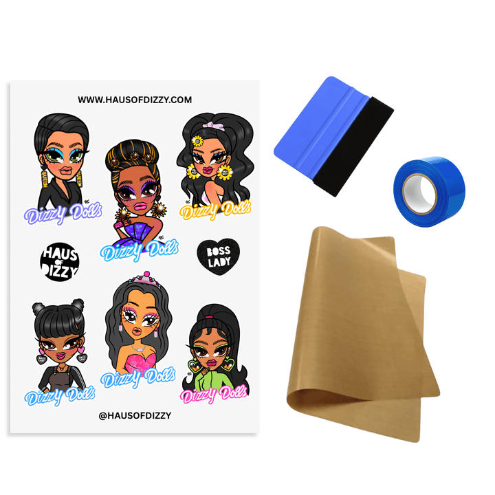 DIY Iron-On Transfer Kit by Haus of Dizzy, featuring a sheet of Dizzy dolls decals, a squeegee, blue heat-proof tape, and brown teflon paper included.