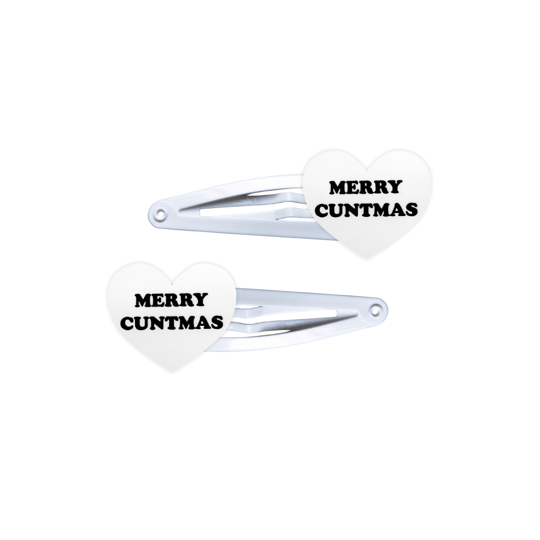 haus of dizzy white, heart shaped hair clips with black text 'MERRY CUNTMAS' on a white background