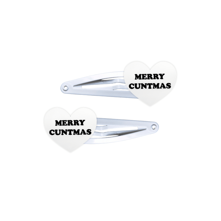 haus of dizzy white, heart shaped hair clips with black text 'MERRY CUNTMAS' on a white background
