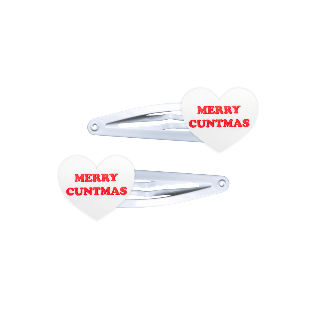 haus of dizzy white, heart shaped hair clips with red text 'MERRY CUNTMAS' on a white background