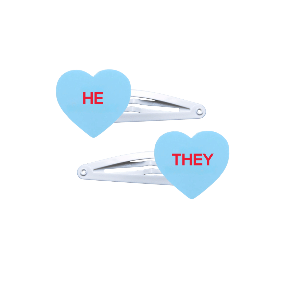 haus of dizzy two pastel blue candy heart acrylic pieces on white hair snap clips with pronouns HE and THEY hand painted red text one word on each hair clip
