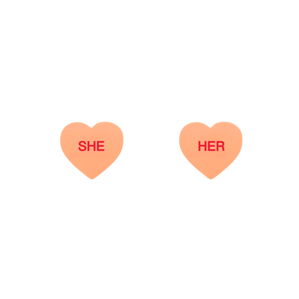 haus of dizzy pastel peach candy heart studs with pronouns SHE and HER in hand painted red text one word on each stud