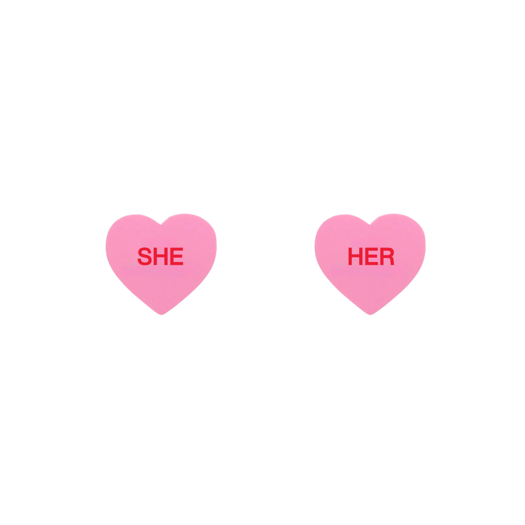 haus of dizzy pastel pink candy heart studs with pronouns SHE and HER in hand painted red text one word on each stud
