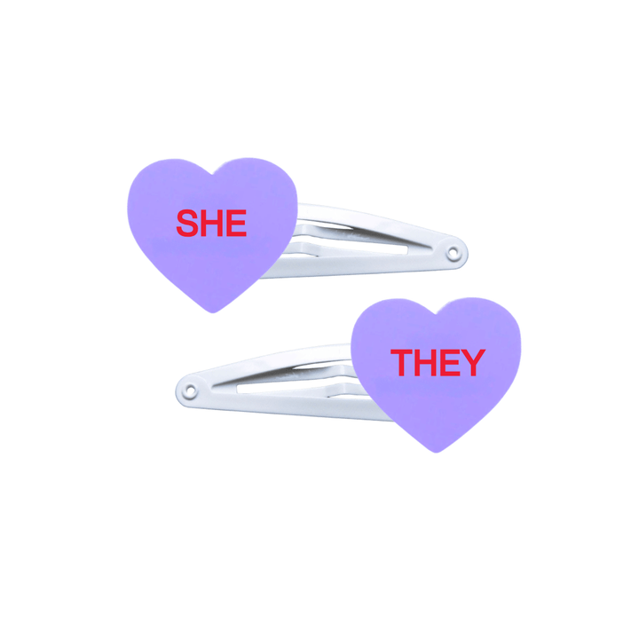 haus of dizzy two pastel grape candy heart acrylic pieces on white hair snap clips with pronouns SHE and THEY hand painted red text one word on each hair clip