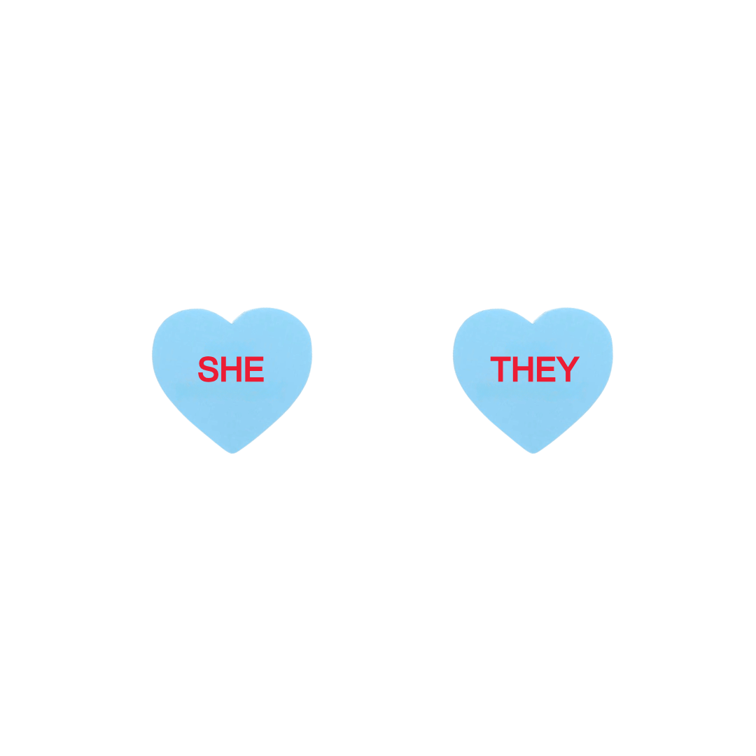 haus of dizzy pastel blue candy heart studs with pronouns SHE and THEY in hand painted red text one word on each stud