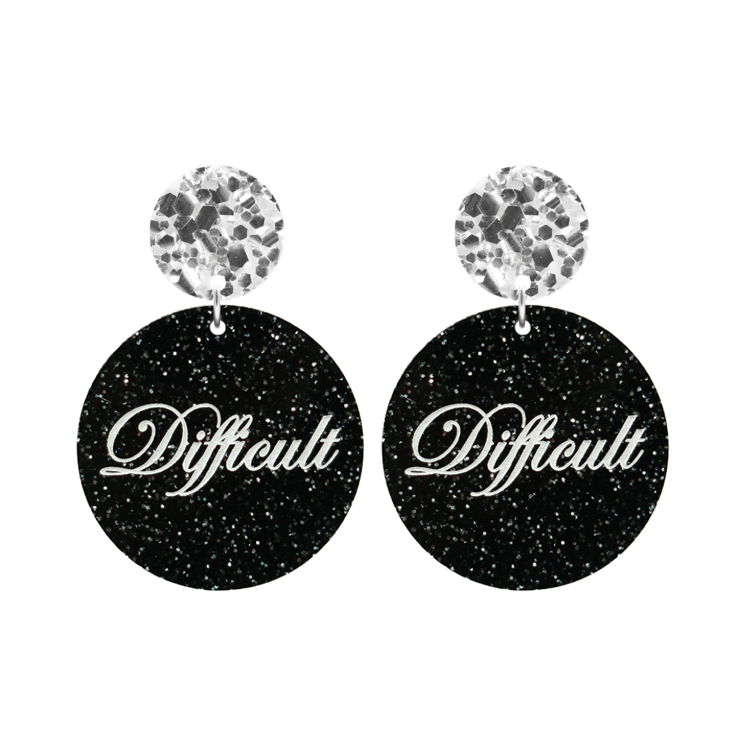 haus of dizzy black glittery circle earrings with cursive text that reads difficult in white, with chunky silver glitter circle tops