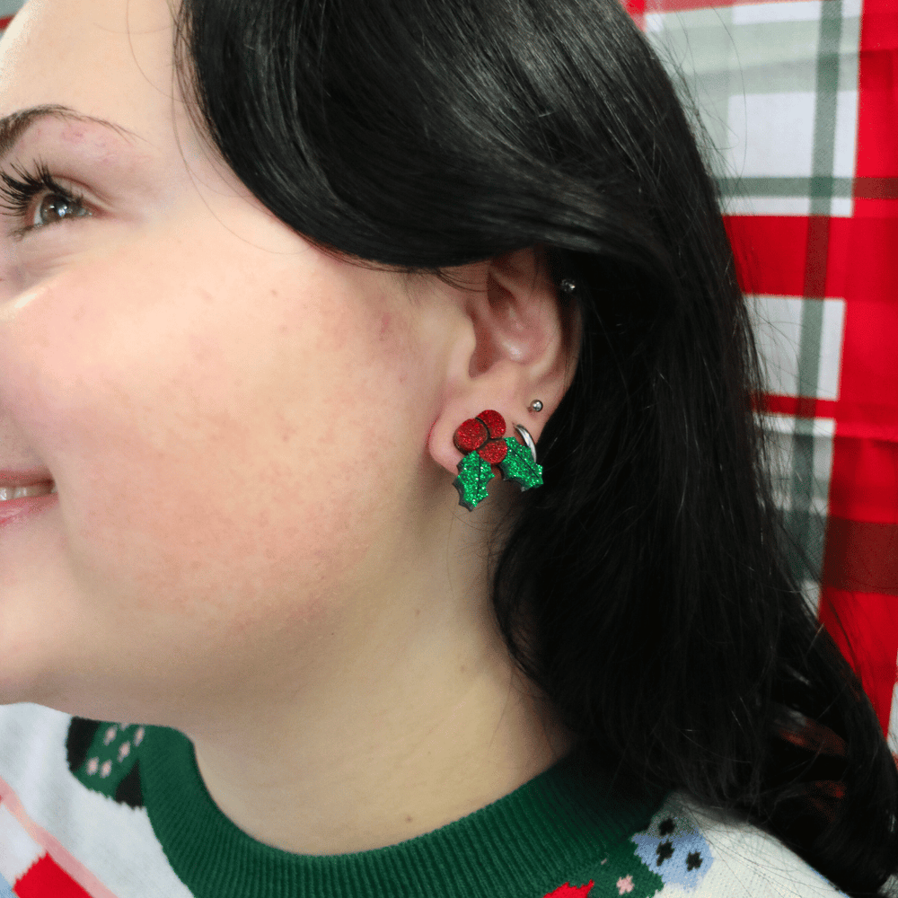 close up of model wearing haus of dizzy kissy sprigs mistletoe glitter studs