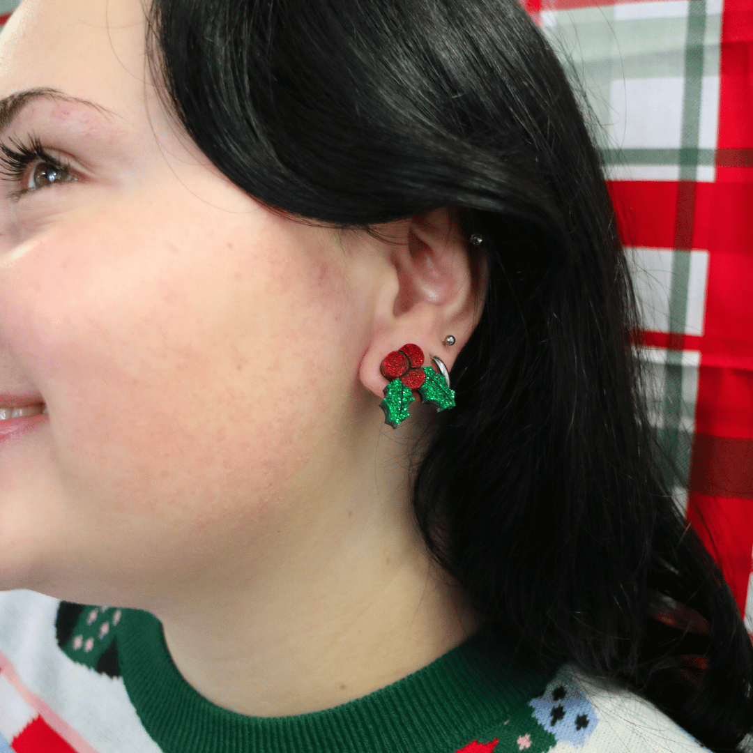 close up of model wearing haus of dizzy kissy sprigs mistletoe glitter studs