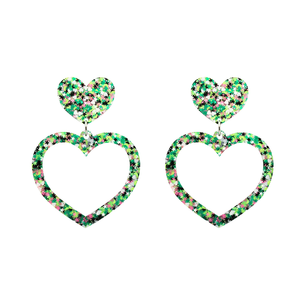 An image of haus of dizzy limited edition barbie heart earrings in colour jungle star. they are two layer heart-shaped earrings with multicolored glitter (greens, white, black, and pink) size small 