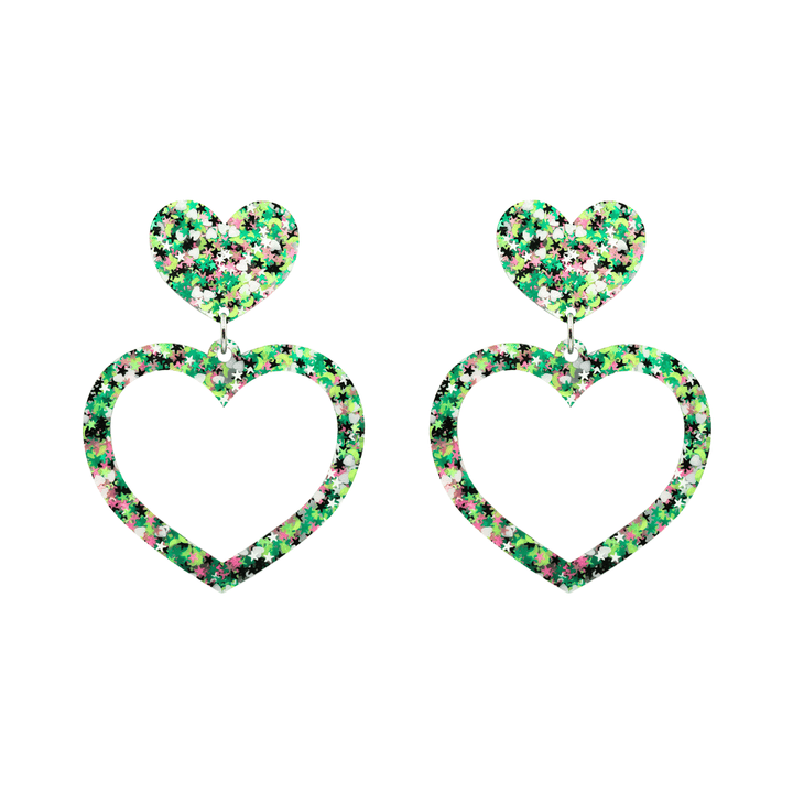 An image of haus of dizzy limited edition barbie heart earrings in colour jungle star. they are two layer heart-shaped earrings with multicolored glitter (greens, white, black, and pink) size small 