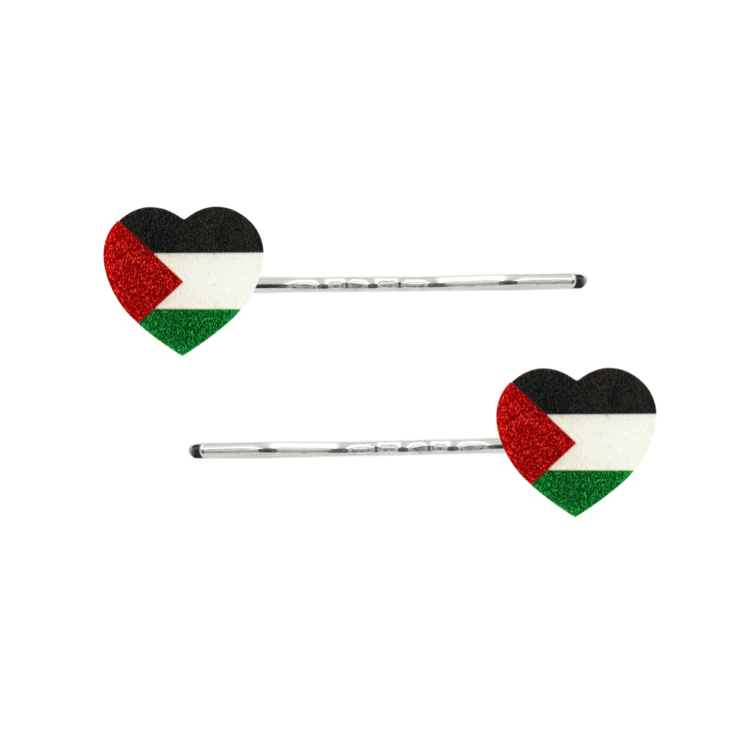 Two silver bobby pins with heart-shaped flags featuring the Palestinian flag design in black, white, red, and green glitter, shown on a plain white background.