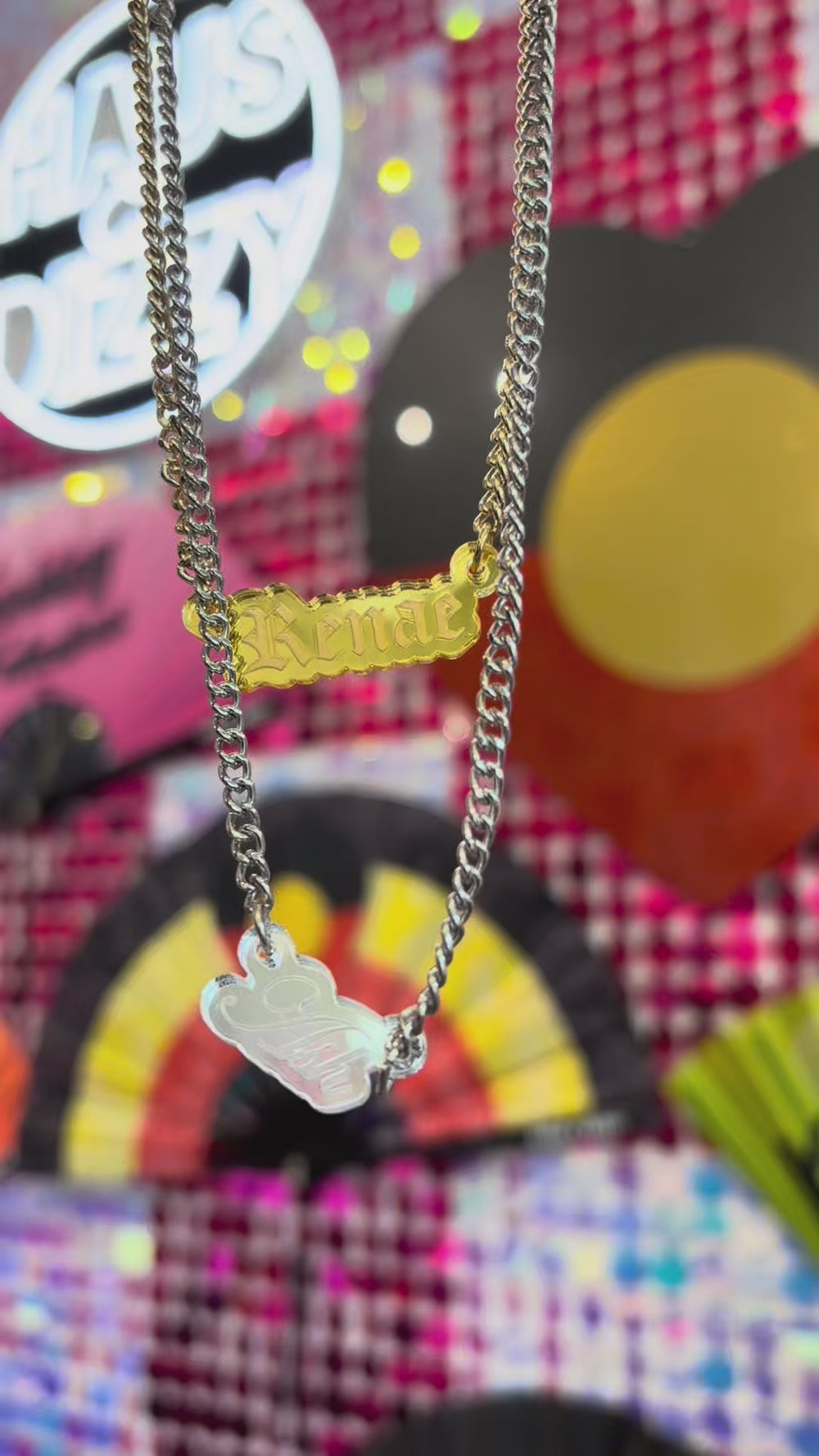 video showing haus of dizzy's mini custom name plate necklaces reflecting in the light. they are made of mirror acrylic handmade in melbourne australia
