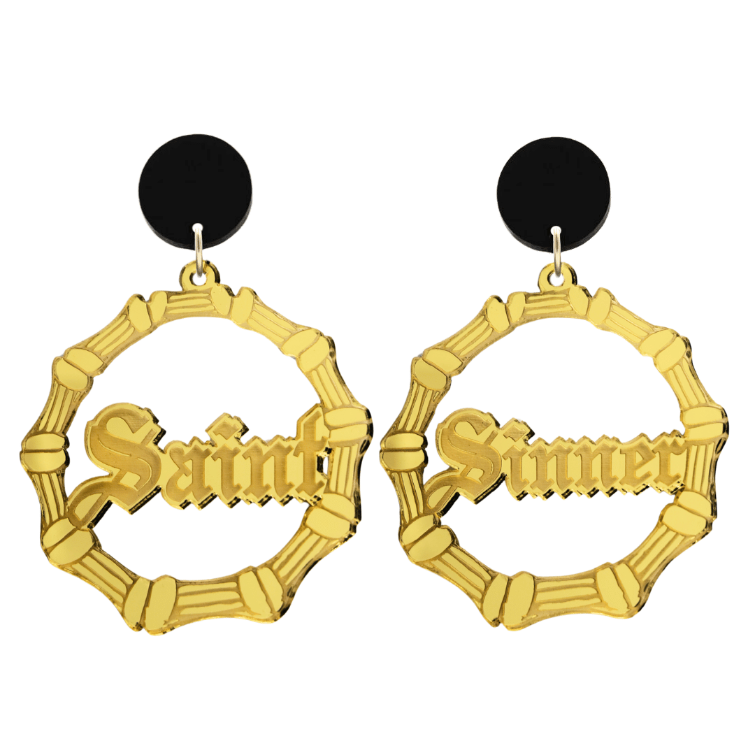 haus of dizzy saint sinner acrylic bamboo hoop earrings in a gothic Old English font, with one hoop reading “Saint” and the other “Sinner,” in a gold mirror acrylic with black circle stud tops size large