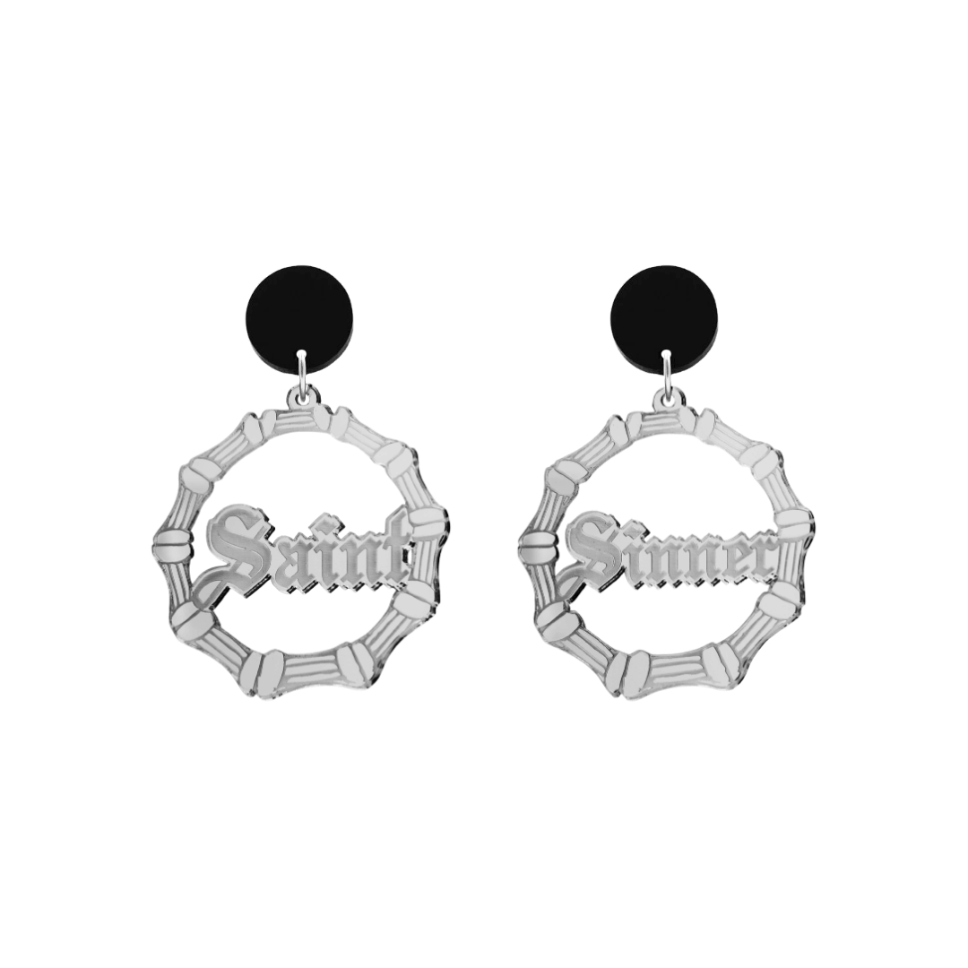 haus of dizzy saint sinner acrylic bamboo hoop earrings in a gothic Old English font, with one hoop reading “Saint” and the other “Sinner,” in a silver mirror acrylic with black circle stud tops size small