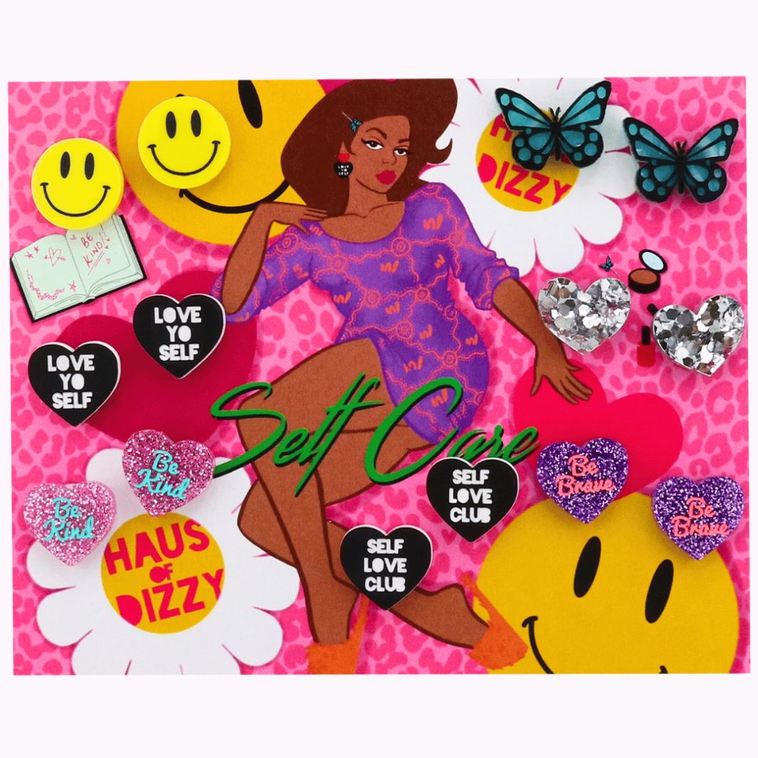 An image of Haus of Dizzy's Self Care Stud Earring Pack, on a Card that has an illustration of a woman lounging in a purple dress and Daisy, smiley face and Love heart Stickers. There are seven pairs of Studs in a variety of colours. Some have slogans that say: Love Yo Self, Be Kind, Self Love Club, Be Brave. Other Studs are glitter heart studs and there is also a pair of Smiley Face and  Butterfly studs.