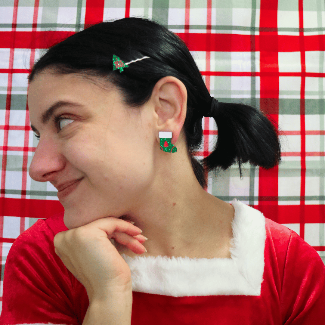 model wearing santa outfit and haus of dizzy twinkle toe glitter stocking studs in green glitter looking away from camera