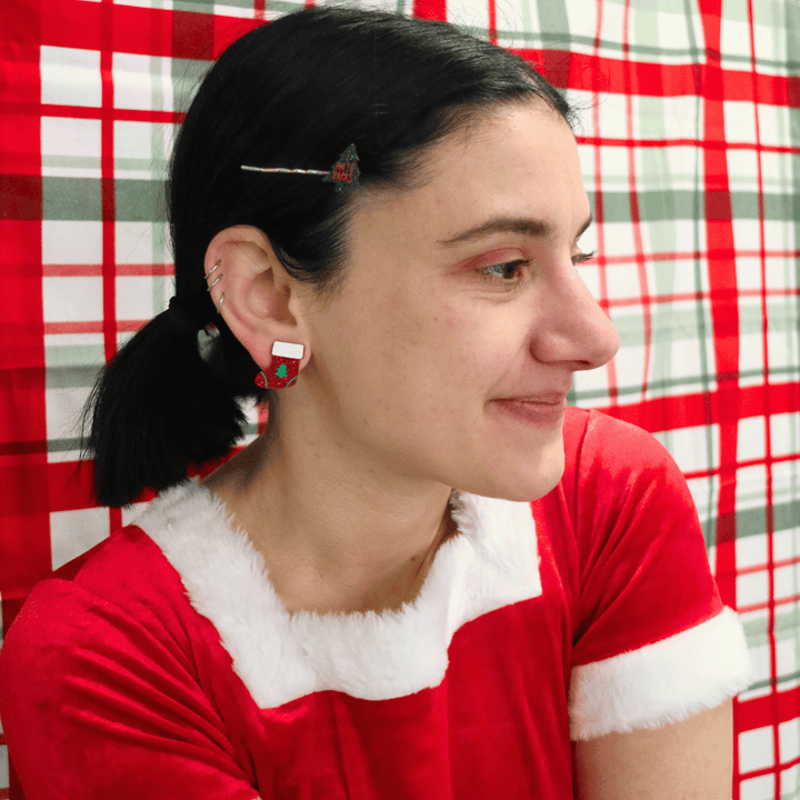 model wearing santa outfit and haus of dizzy twinkle toe glitter stocking studs in red glitter looking away from camera