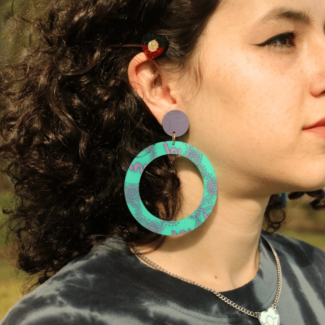 close-up of a model wearing haus of dizzy wiradjuri yinaa hoop earrings in dusty teal colour